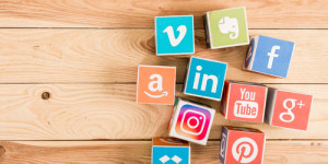Various social media icons on wooden table