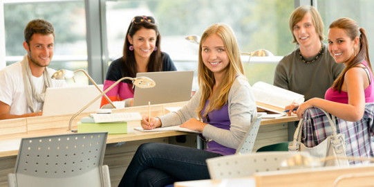 Seminarsituation 6 Studierende in hellem Unterrichtsraum blicken lächelnd in Richtung Kamera