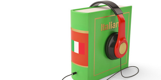 Book in green with Italian inscription, headphones placed on the book.
