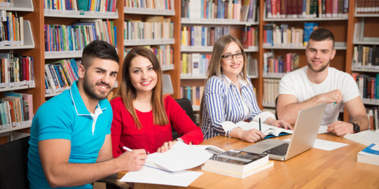 Writing Group 4 students in a study situation, sitting in a semicircle around a table, in conversation