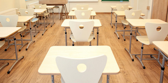 Classroom with empty white tables and chairs