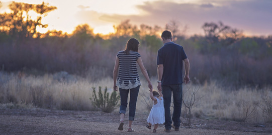 Famileie von hinten in Natur und Sonnenuntergang