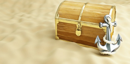 Vocabulary Treasure chest on sand, closed with an anchor