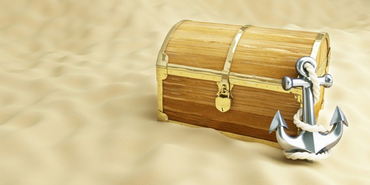 Treasure chest on sand, closed with an anchor