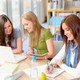 3 Studentinnen sitzen am Tisch und lernen gemeinsam