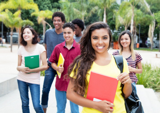 Gruppe internationale Studierende im Freien auf den Betrachter zukommend