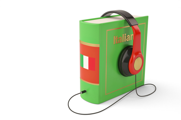 Aufgestelltes Buch in Grün mit Aufschrift Italienisch, Kopfhörer auf dem Buch platziert