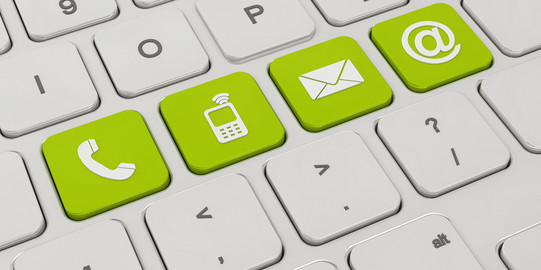 Auf einer weißen Tastatur sind vier Tasten grün eingefärbt. Darauf zu sehen sind Symbole für ein Telefon, ein Mobiltelefon, ein Briefumschlag und ein "at"-Zeichen.